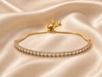 Elegant Gold-Tone Adjustable Tennis Bracelet for Women with Sparkling Round Crystal Stones, Slim Chain Design and Sliding Bolo Clasp, Stylish Fashion Jewellery for Party, Wedding, Festive and Everyday Wear